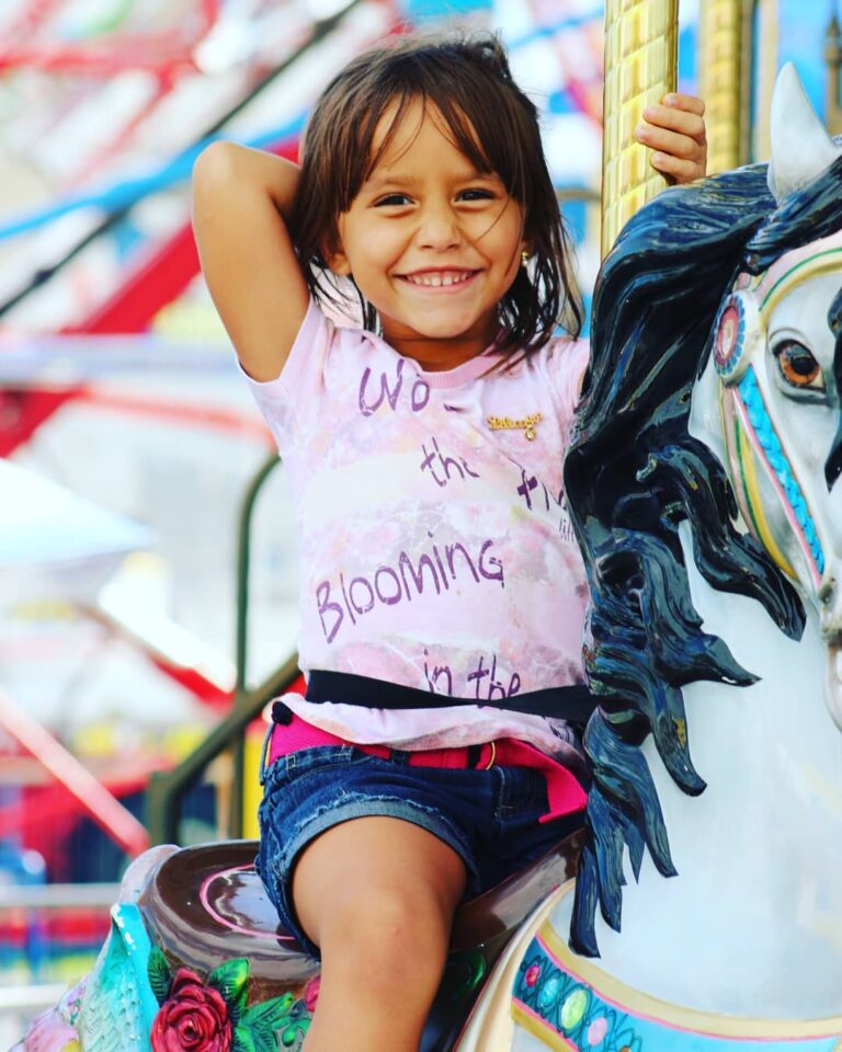 Little girl smiling on a carousel ride